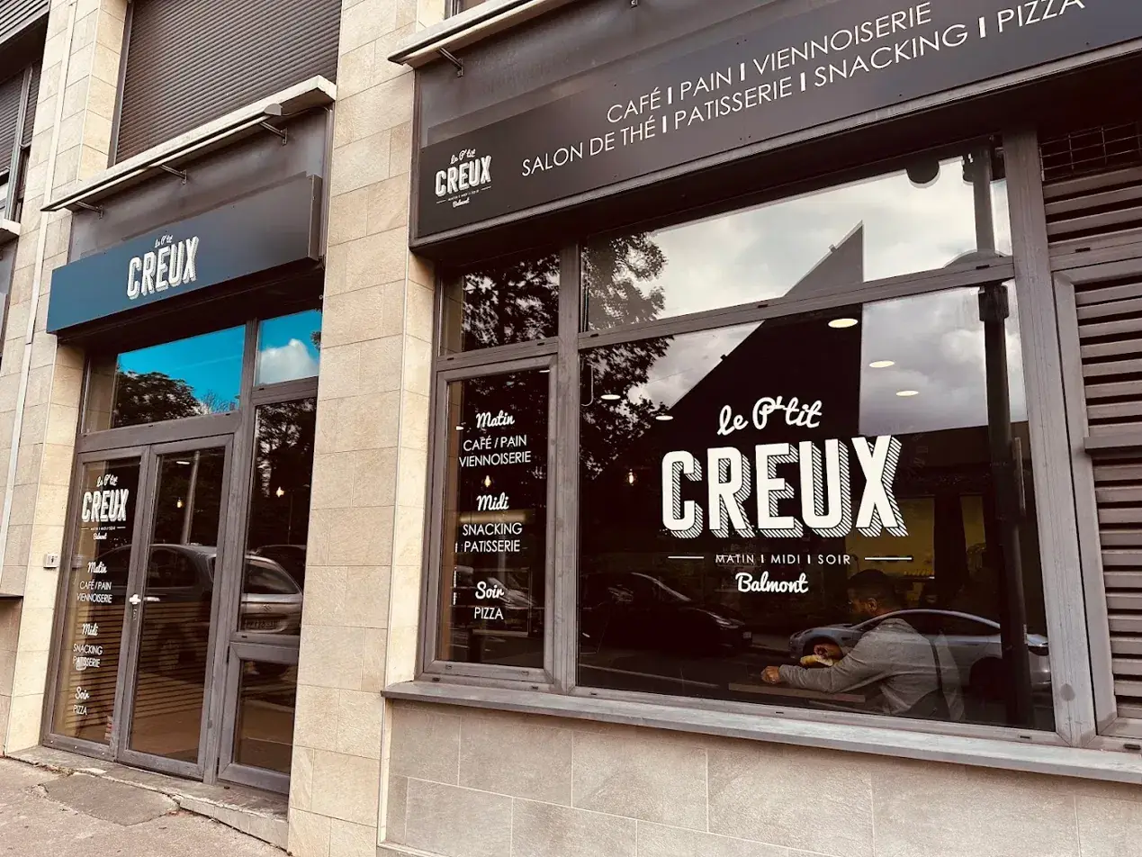 La devanture du P'tit Creux Balmont : une grande vitrine avec le lettrage de la boutique et une enseigne au-dessus de la porte